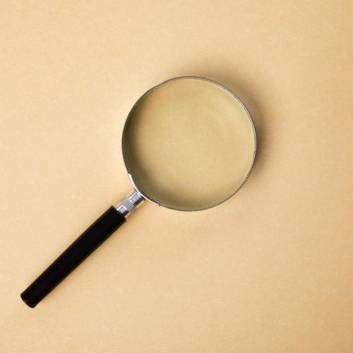 Magnifier on an orange background. Concept search